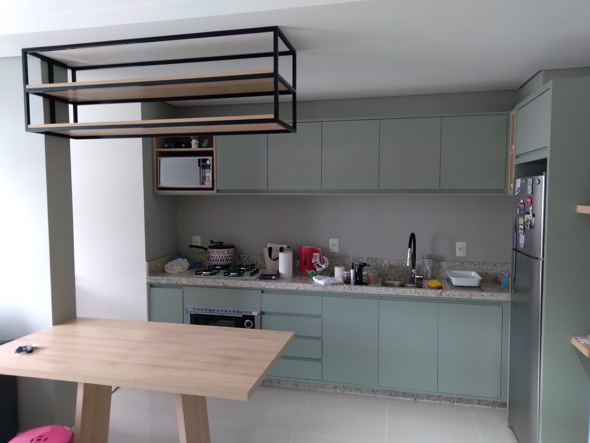 Cozinha verde com mesa integrada